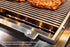 Tucker R Class BBQ gas burner flames beneath the stainless steel cooking grill on the Cypriot Attachment