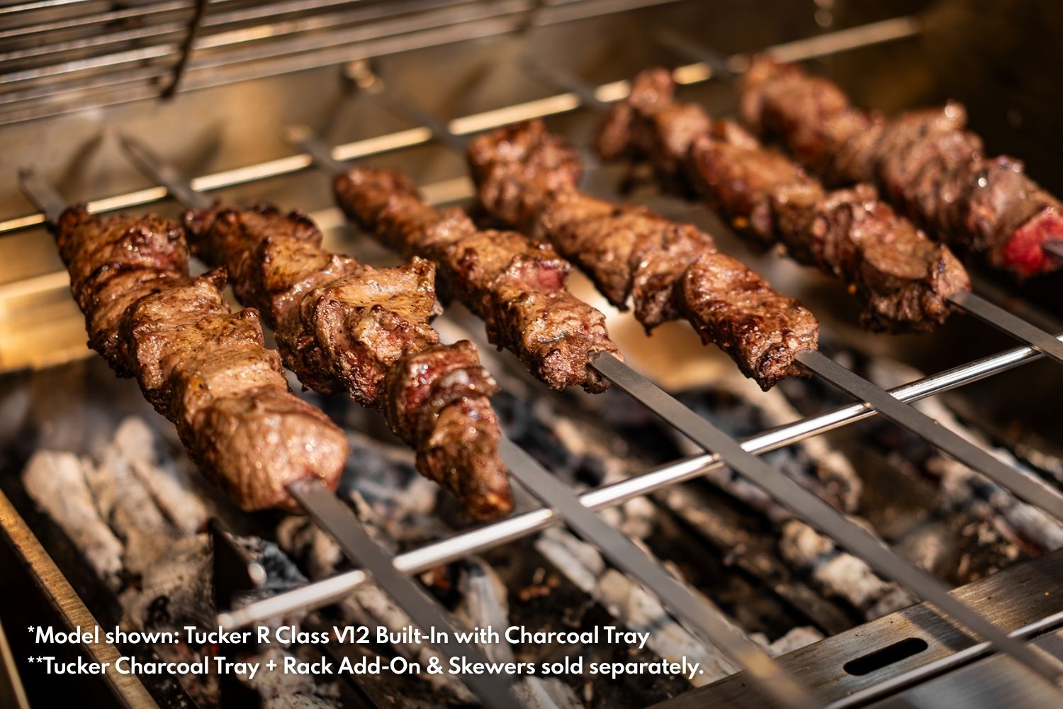 Beef rump cap skewers browning over charcoal on the rack above a Tucker BBQ charcoal tray